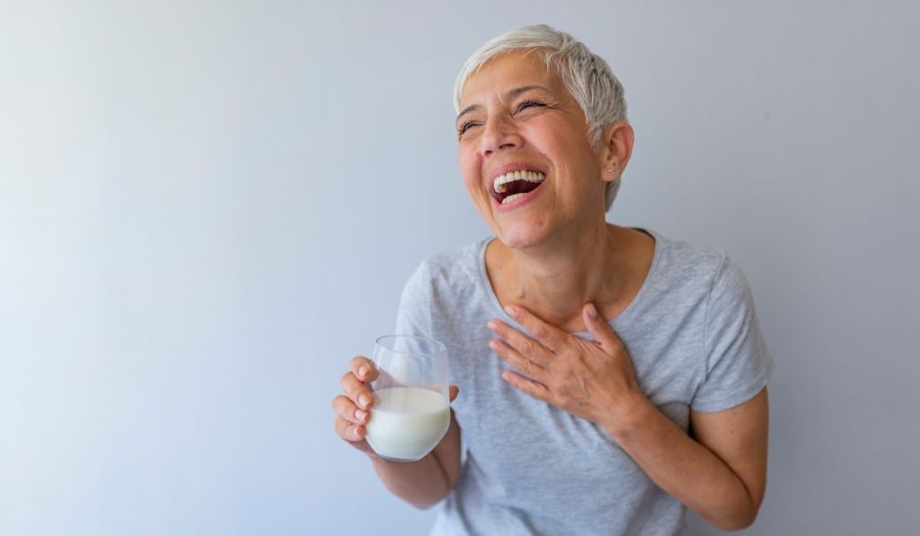 This photo shows a menopausal woman drinking milk to get more calcium as a way to cope with menopause.